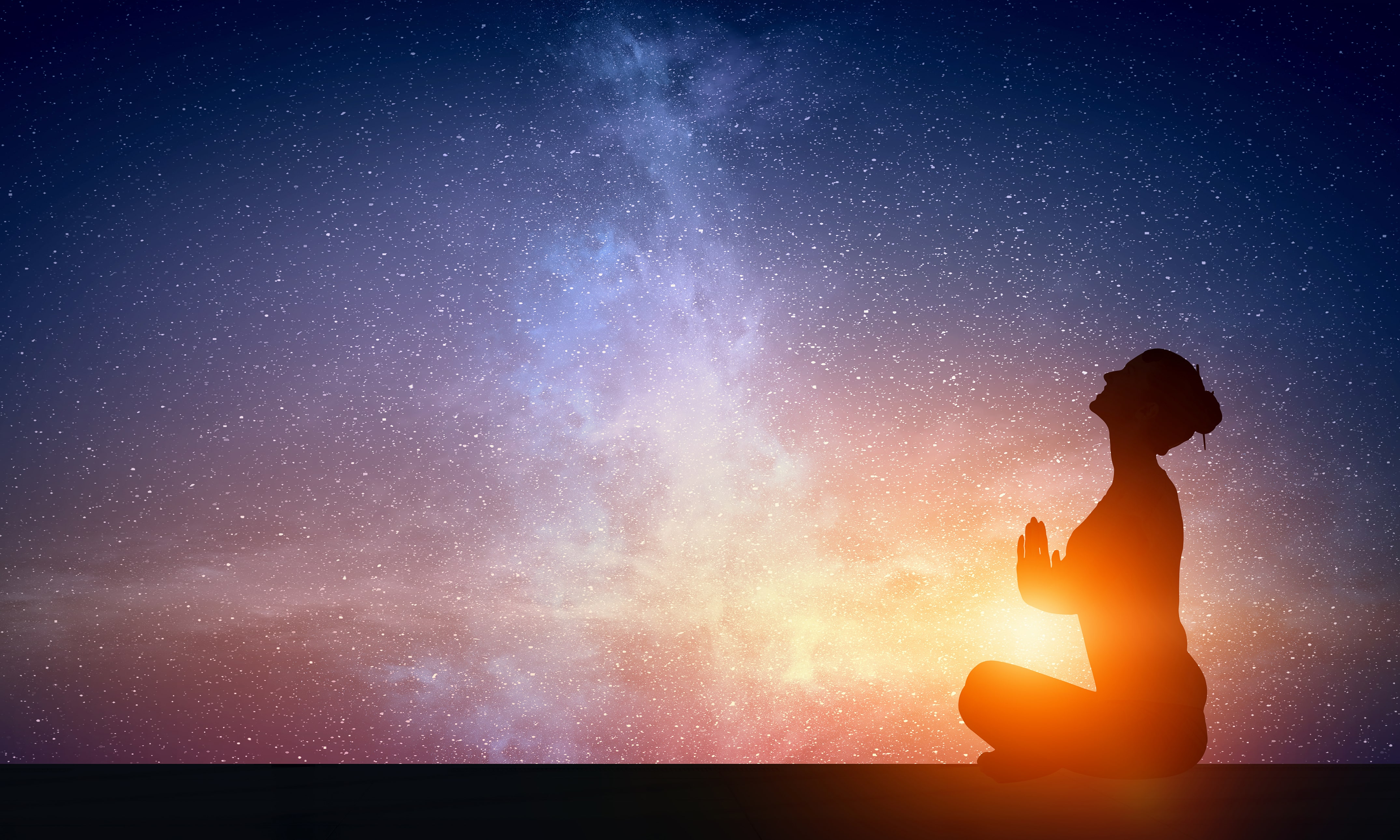 woman doing yoga with the night sky in the background