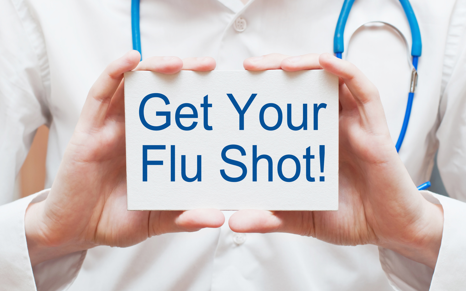 Doctor holding flu shot announcement