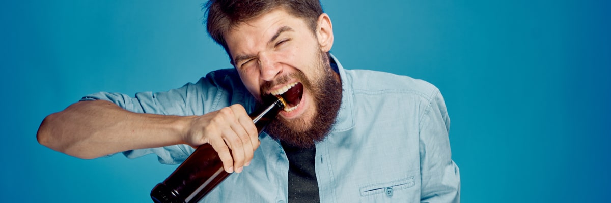 Man opening alcohol with teeth