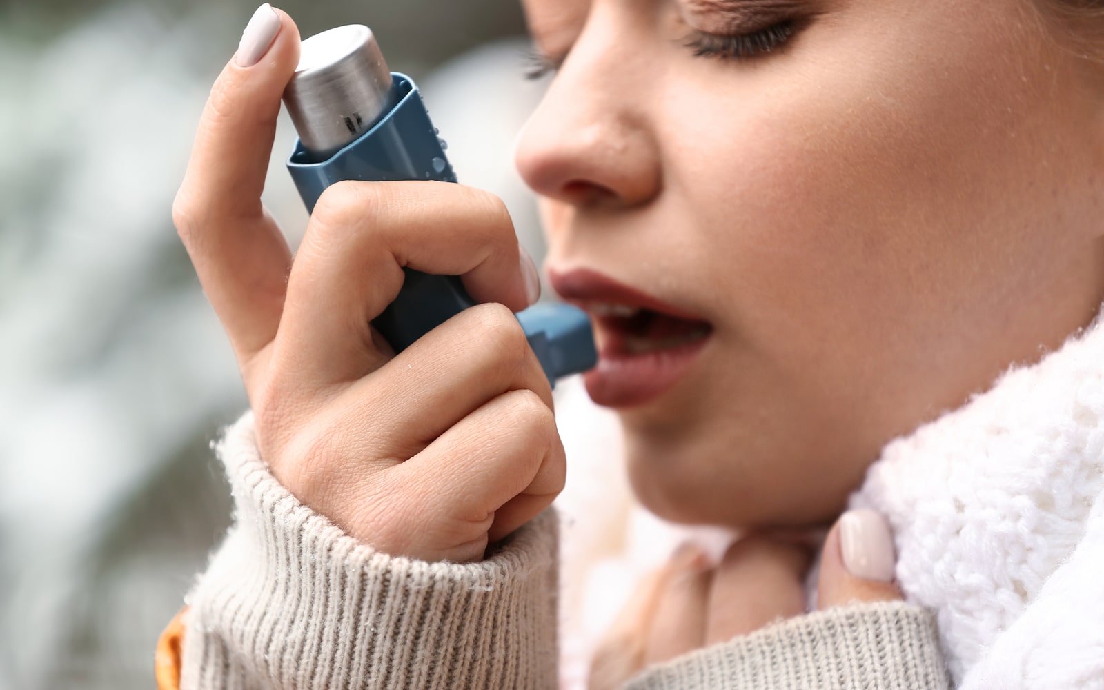 Woman using asthma inhaler